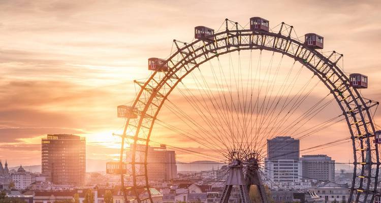 Atardecer detrás de la histórica noria de Viena con el horizonte de la ciudad.