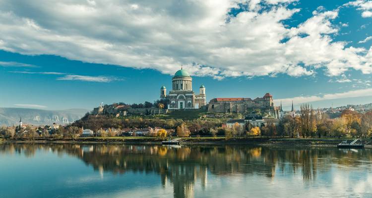 La majestuosa Basílica de Esztergom corona una colina junto al río reflejándose en el Danubio bajo nubes dramáticas.