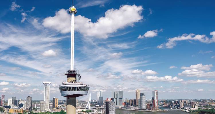 Horizonte de Rotterdam con torres modernas dominado por la torre de observación Euromast bajo nubes tenues.