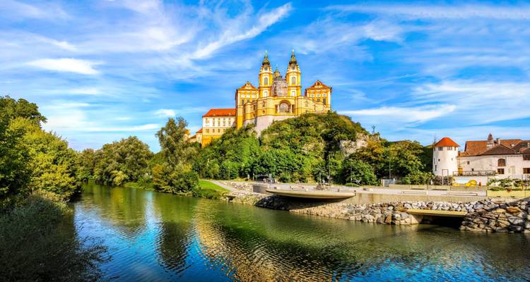 La magnifique abbaye de Melk couronnée de jaune baroque au sommet d'une colline boisée au-dessus du Danube.