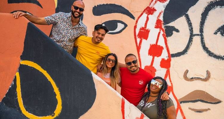 Group of people in front of a colorful mural