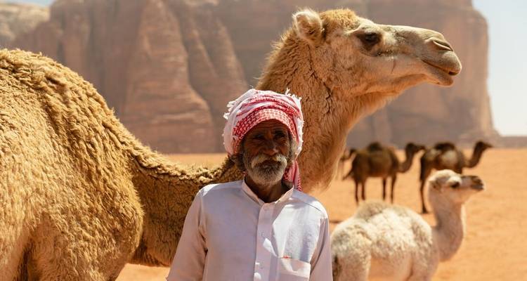 Man standing with camels in a desert