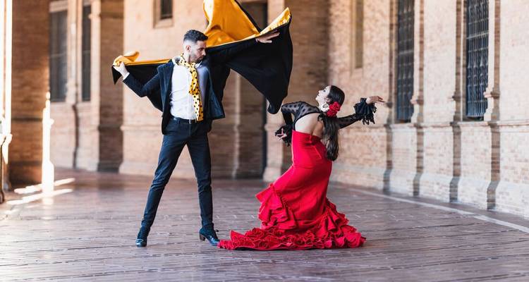 Des danseurs et danseuses de flamenco se produisant de manière dramatique dans une arcade historique.