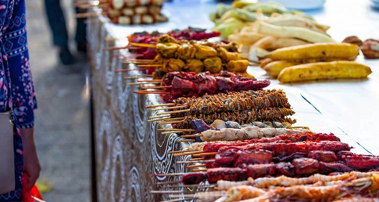 Close-up image of a market stall laden with skewered foods.