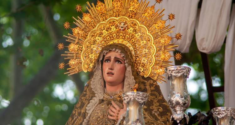 Elaborada estatua dorada de la Virgen María de una procesión de Semana Santa española.