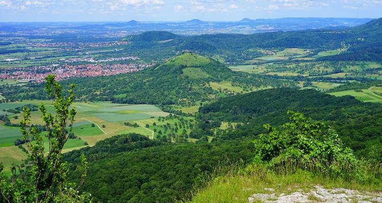 Panoramablick auf ein Tal mit Straßen und Feldern.