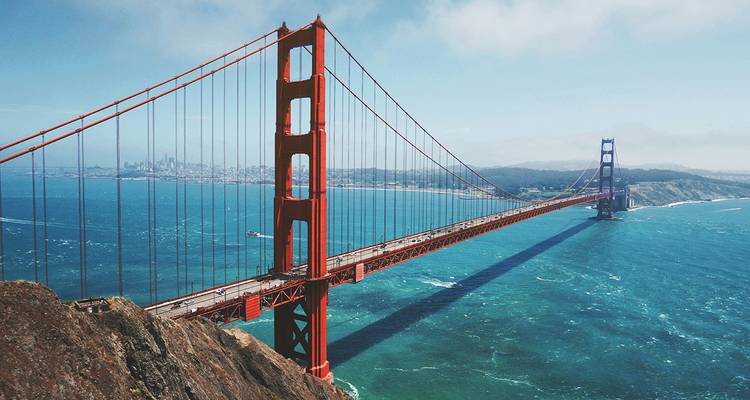 Pont du Golden Gate enjambant les eaux turquoise avec l'horizon de San Francisco en arrière-plan