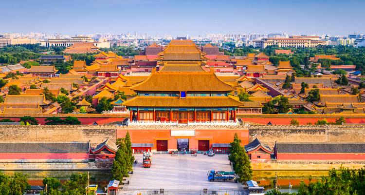Vista aérea de la Ciudad Prohibida de Beijing con techos dorados extendiéndose hacia el horizonte moderno.