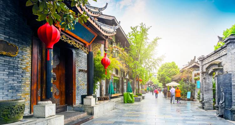 Calle peatonal tradicional en Chengdu adornada con faroles rojos y arquitectura de madera histórica.