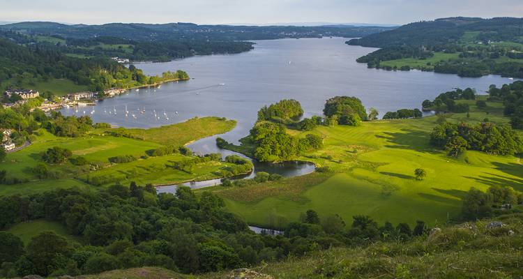 Malerische Aussicht auf einen See, umgeben von grünen Hügeln.