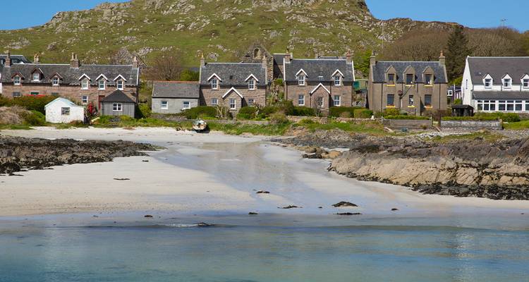 Village côtier avec plages de sable et affleurements rocheux.