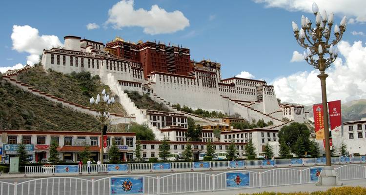 Beroemd paleis met witte muren en rode daken omgeven door weelderig groen.