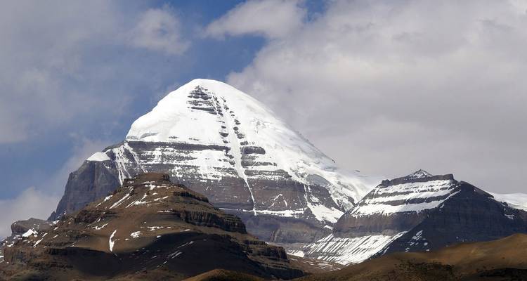 Besneeuwde bergtop tegen een blauwe lucht.