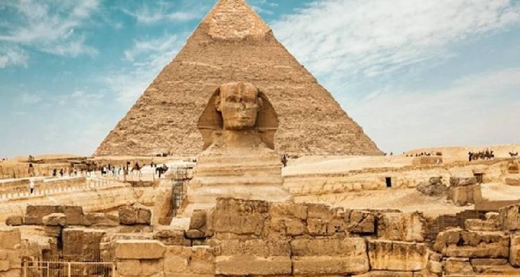 The Great Sphinx of Giza with a pyramid in the background.