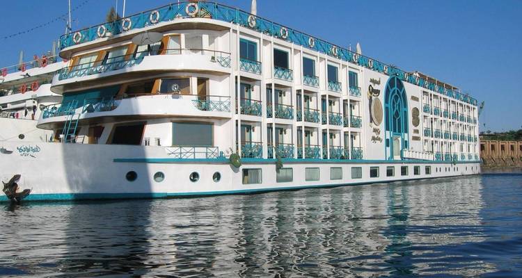 Grand navire de croisière amarré sur une rivière.