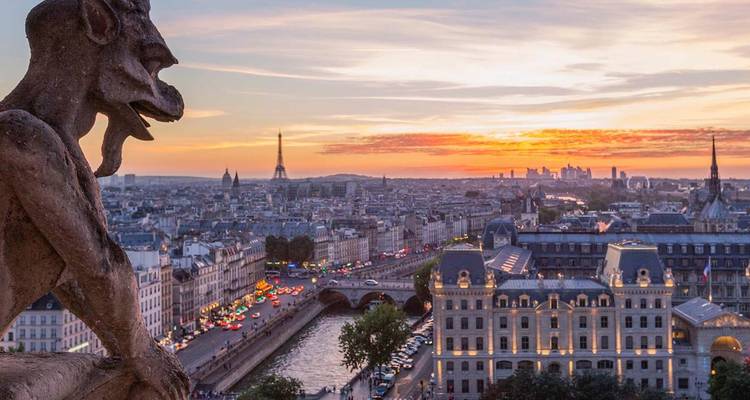 Steinerne Wasserspeier blickt bei Sonnenuntergang über Paris mit Eiffelturm und der von Stadtlichtern beleuchteten Seine.