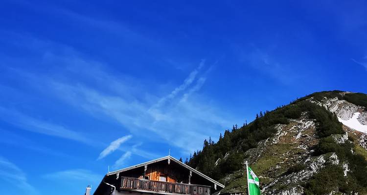 Partial view of a mountain cabin with blue sky.