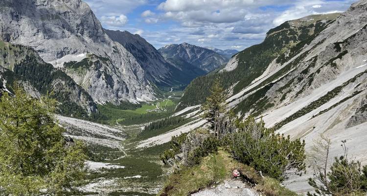 Wanderweg durch dramatisches Bergtal mit Panoramablick.