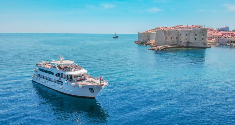 Yacht près d'un fort historique en pierre sur l'eau.