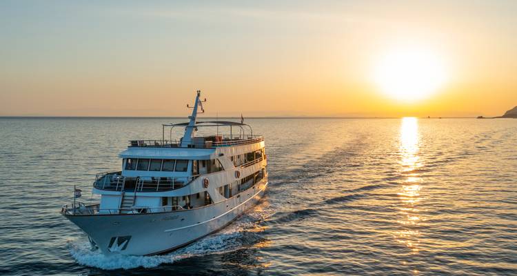 Boot op het water tijdens zonsondergang met een heldere lucht.