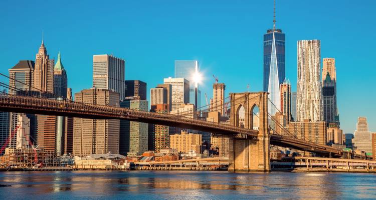 Classic Brooklyn Bridge view with sparkling skyscrapers of Lower Manhattan in crisp morning light.