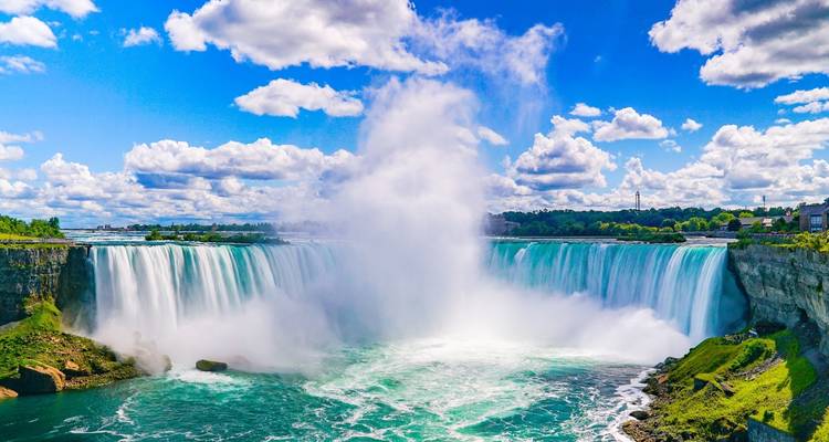 Vue diurne des chutes Horseshoe avec un puissant panache de brume contre un ciel lumineux.