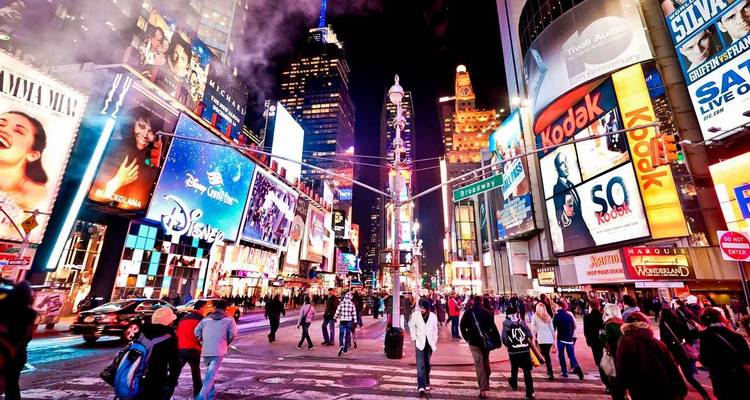 Crowds and bright billboards light up Times Square at night in New York City.