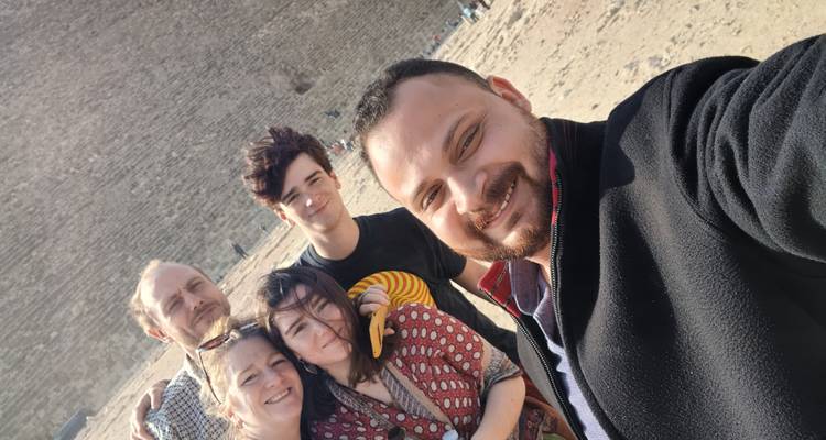 Selfie de una familia con un telón de fondo de piedra histórica.