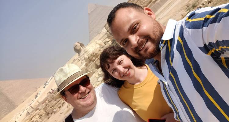 Un grupo alegre tomándose una selfie con pirámides de fondo.