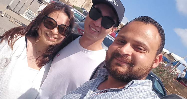 Tres personas tomándose una selfie en un entorno exterior soleado.