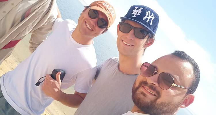 Un grupo de cuatro personas disfrutando de una salida a la playa.