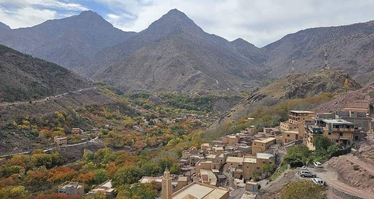 Vista de un pueblo de montaña rodeado de follaje otoñal colorido.