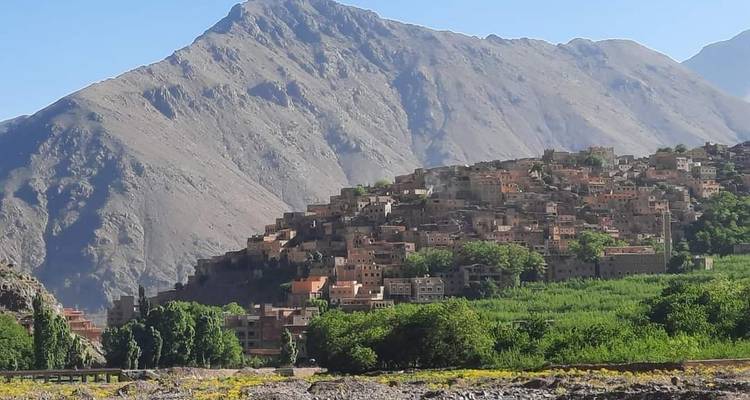 Paisaje montañoso con un pueblo enclavado entre exuberante vegetación.