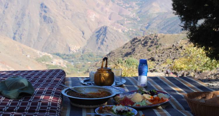 Picnic al aire libre con comida tradicional con vista a un paisaje montañoso.