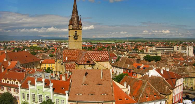 Vista panorámica de una ciudad con una iglesia histórica y tejados coloridos.
