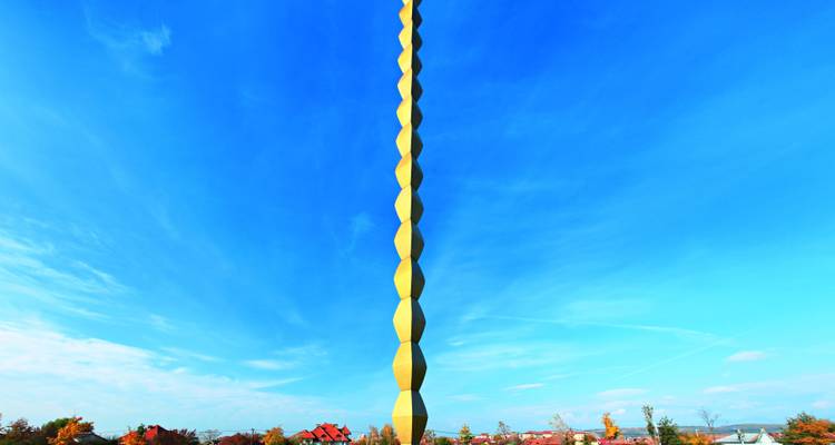 Escultura moderna alta que se eleva hacia el cielo.