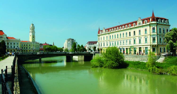 Vista de la ciudad ribereña con edificios históricos y modernos.