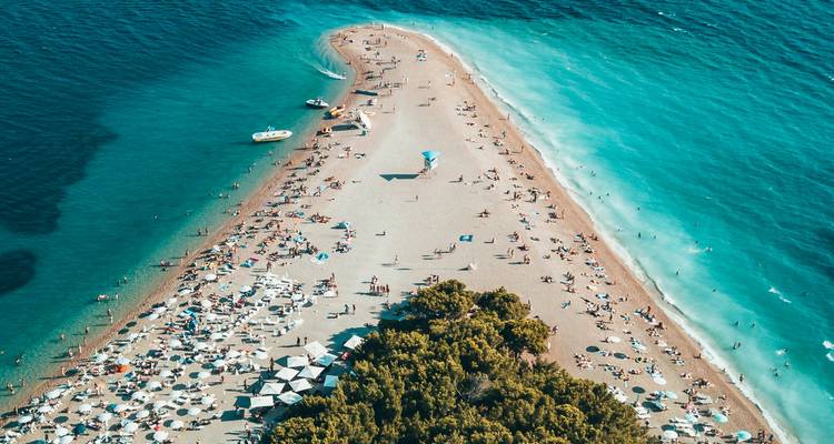 Vue aérienne d'une presqu'île de plage avec des eaux turquoise.