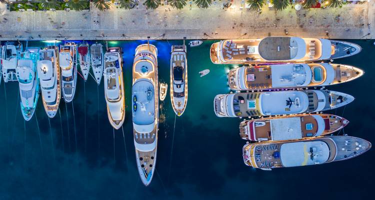 Yachts amarrés la nuit avec les lumières de la ville.