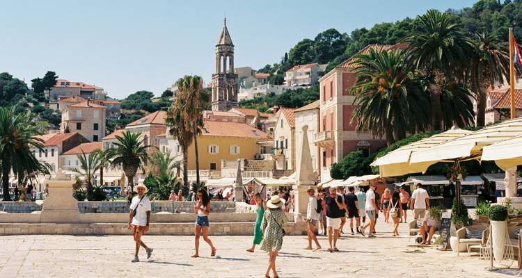 Toeristen die een levendig stadsplein verkennen.