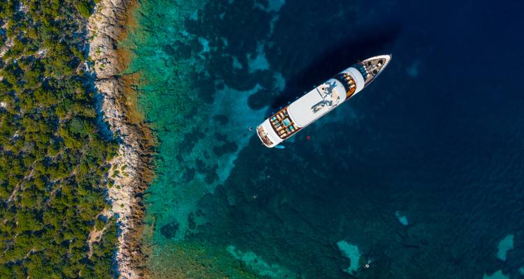 Luchtfoto van een jacht nabij de Kroatische kustlijn.