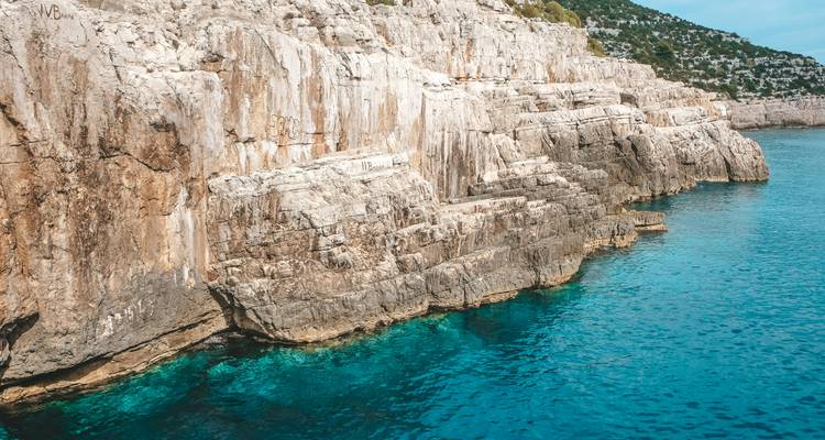 Cliffs alongside clear blue water.