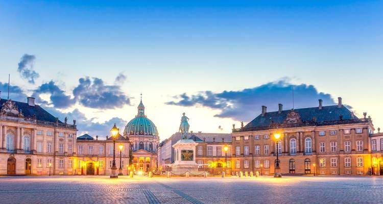 Vroege avondlicht op het Amalienborg Paleisplein met de koepel van de Marmerkerk in Kopenhagen tegen een pastelkleurige hemel.