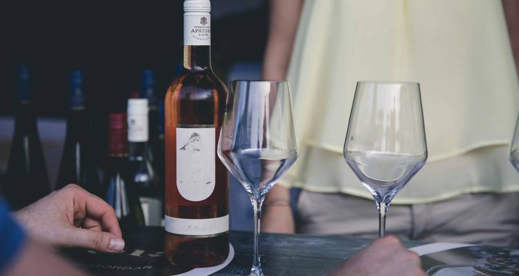 Table avec plusieurs bouteilles de vin et verres.