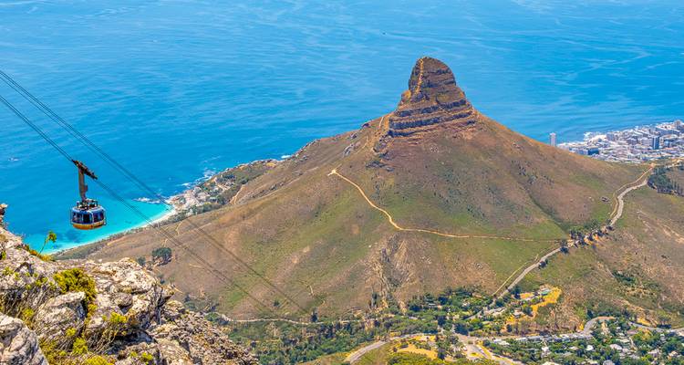Die Seilbahn erklimmt einen Berg mit Blick auf den Lion's Head Peak und die leuchtend blaue Atlantikküste.