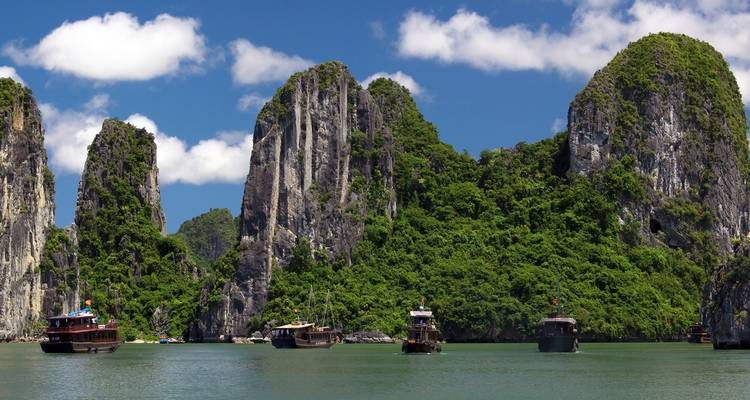 Halong Bay with limestone karst formations and boats on water.