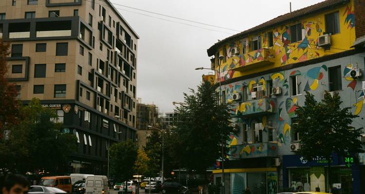 Vue de rue avec des bâtiments colorés et des arbres.