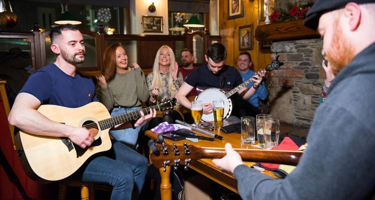 Groupe de personnes profitant d'une session de musique live dans un pub chaleureux.