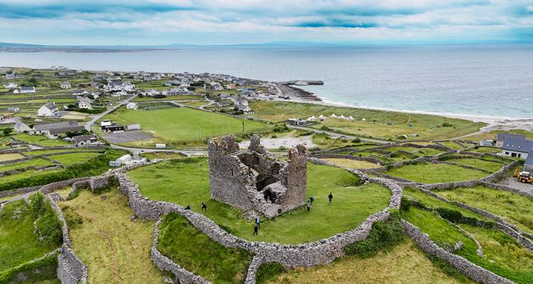 Vue aérienne d'un fort historique en pierre avec océan et campagne.