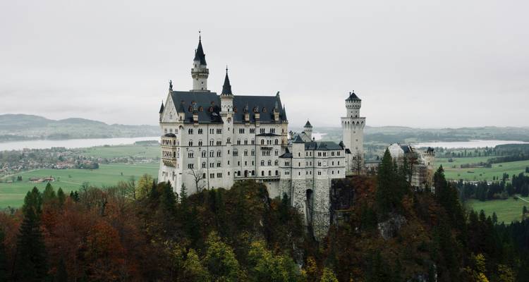 Schloss Neuschwanstein umgeben von üppiger grüner Landschaft.